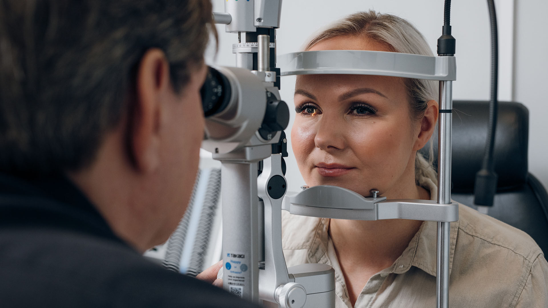 Nainen optikon vastaanotolla mikroskooppitutkimuksessa
